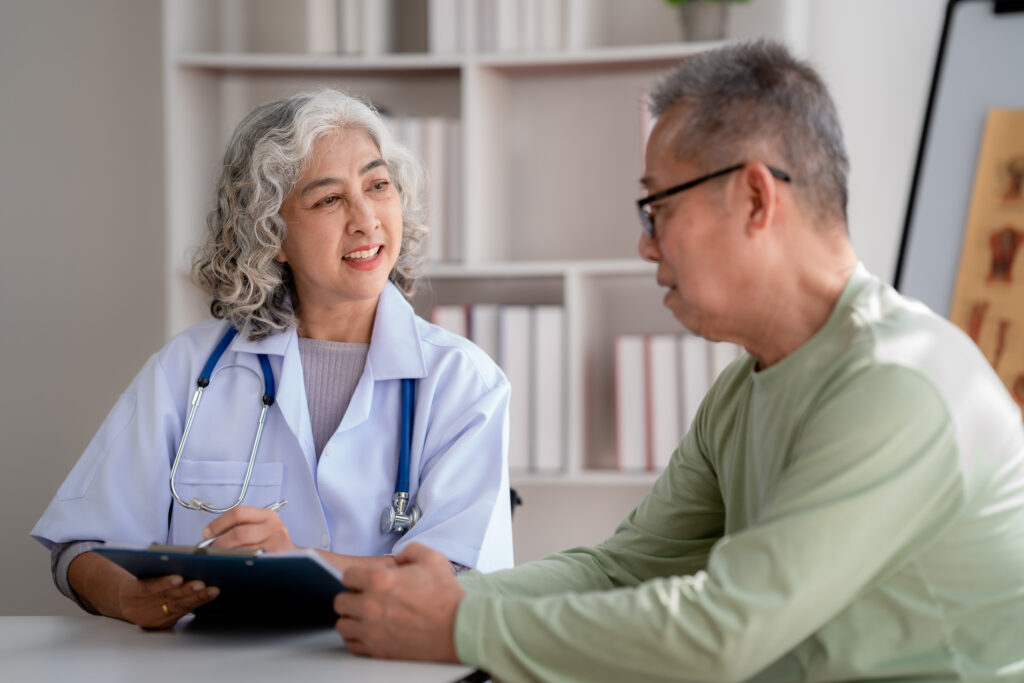 a female doctor meeting with an elderly patient who asked "does Medicare cover rehab"?