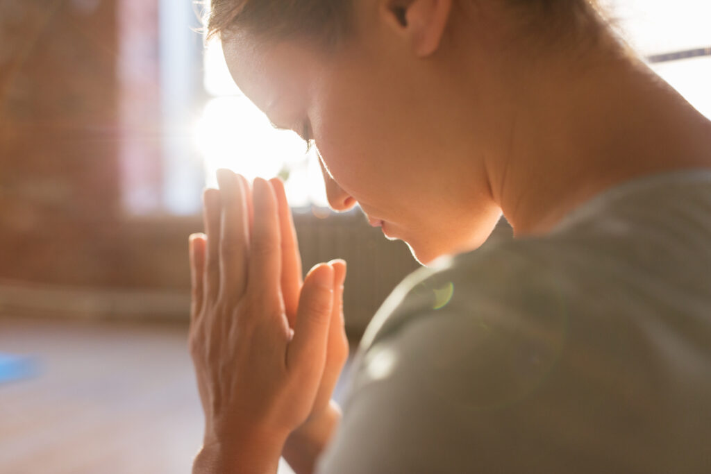close up of a woman praying as part of religion and addiction