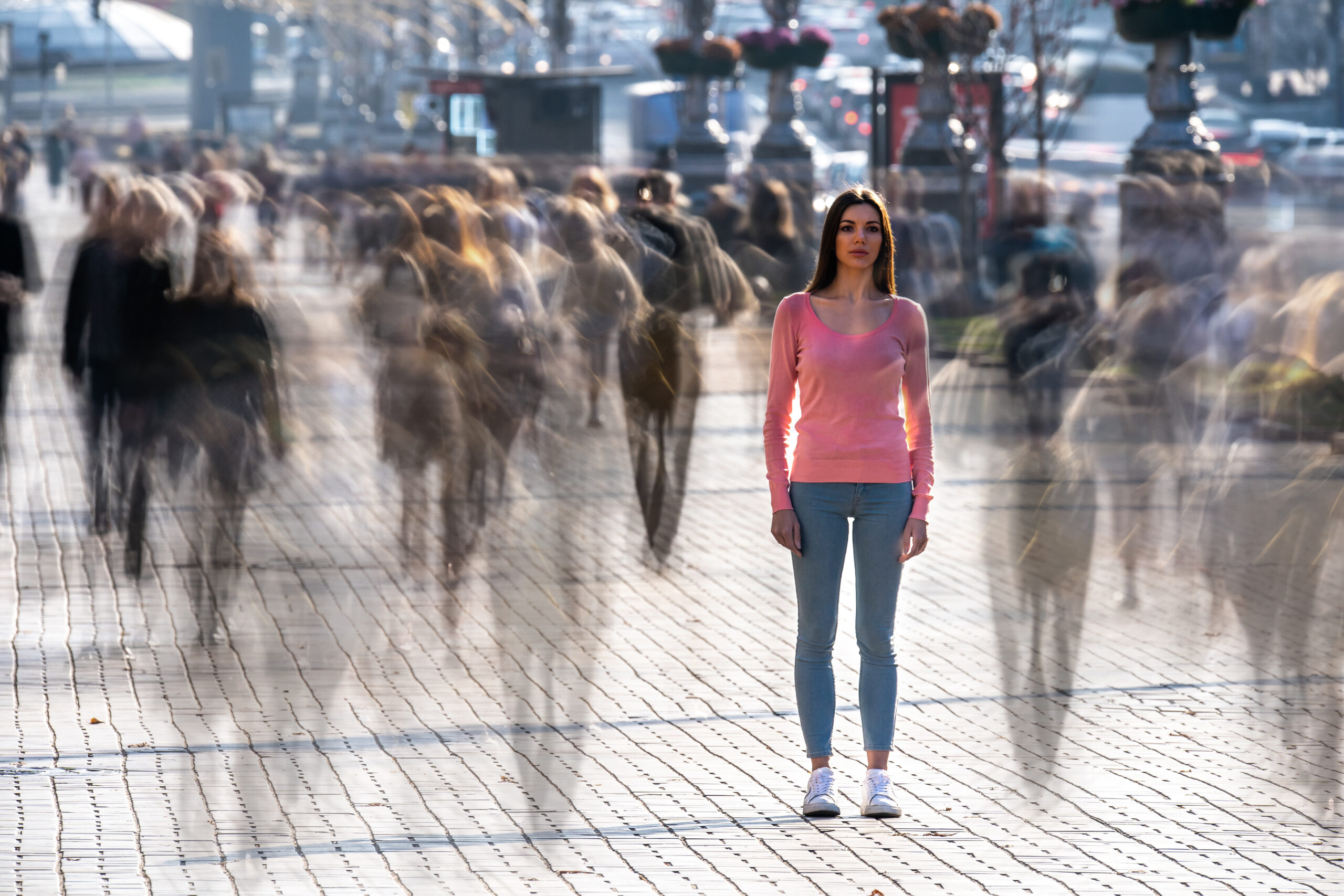 a woman standing in the middle of the street with a blurred background as part of her substance induced psychosis
