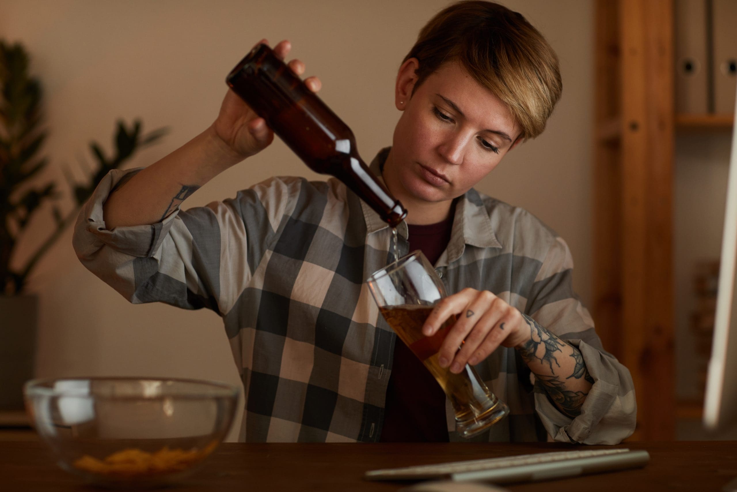 a functioning alcoholic pouring beer into a glass
