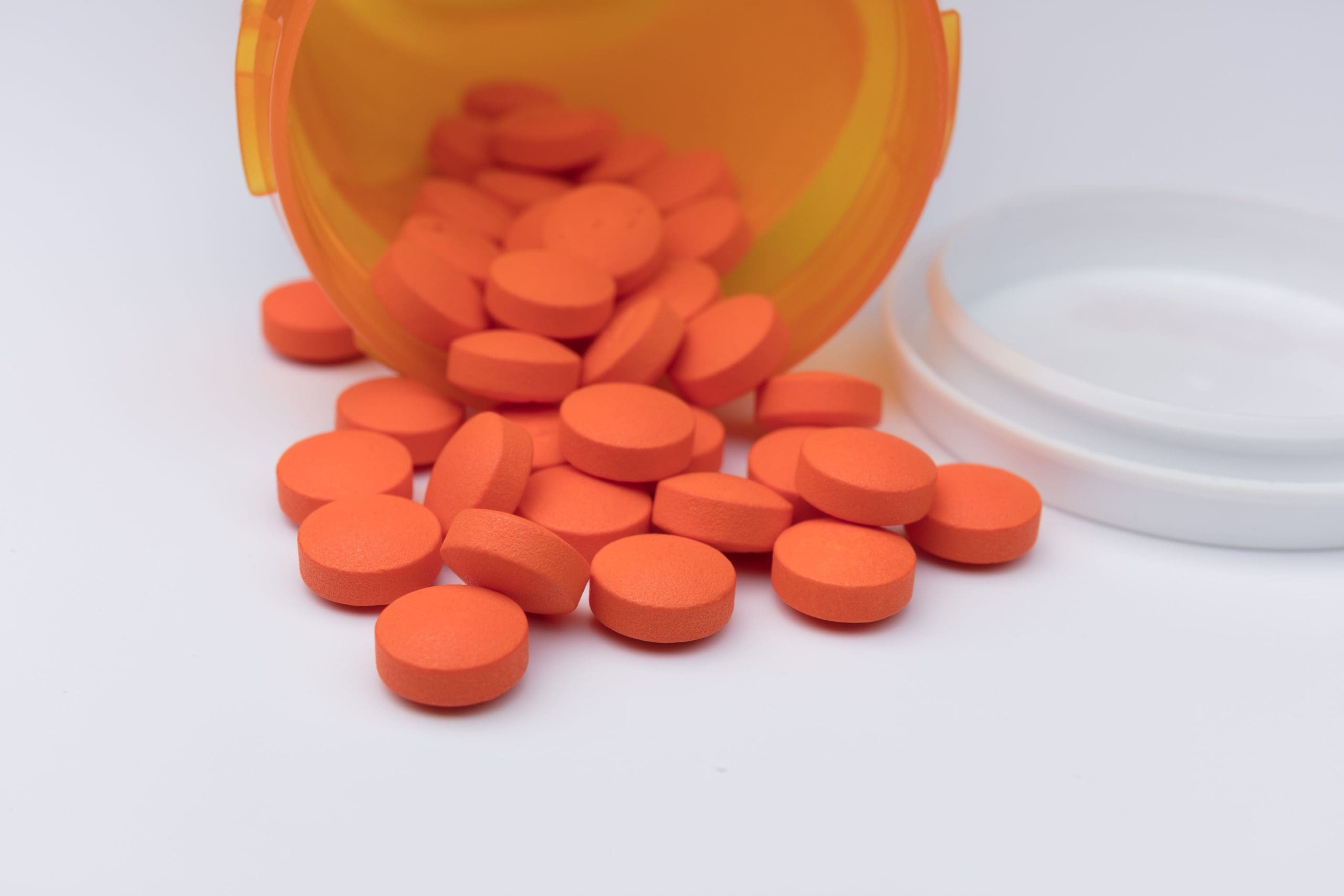 pills spilling out of a pill bottle, suggesting adderall and liver damage