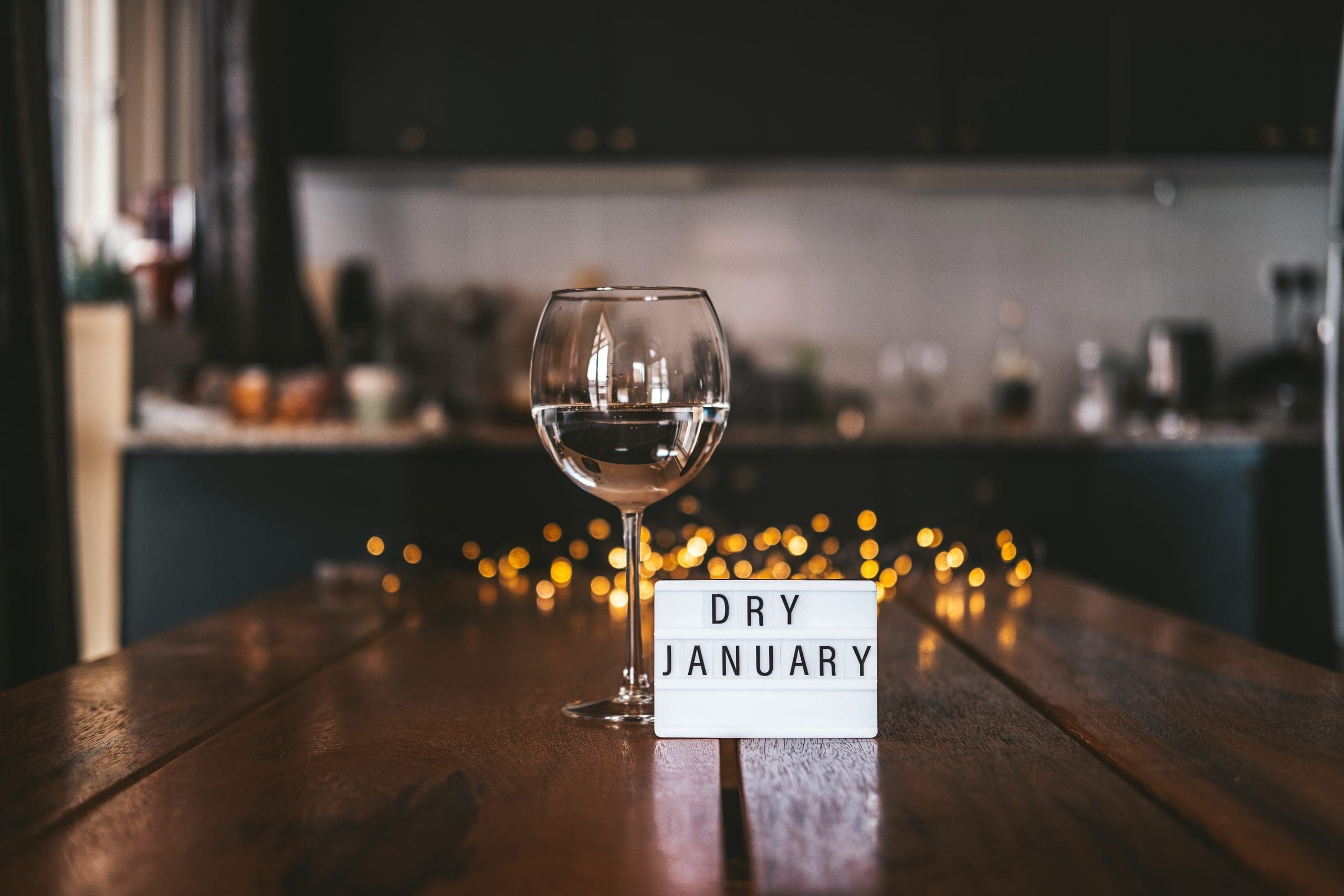 empty wine glass on table with "dry january" sign