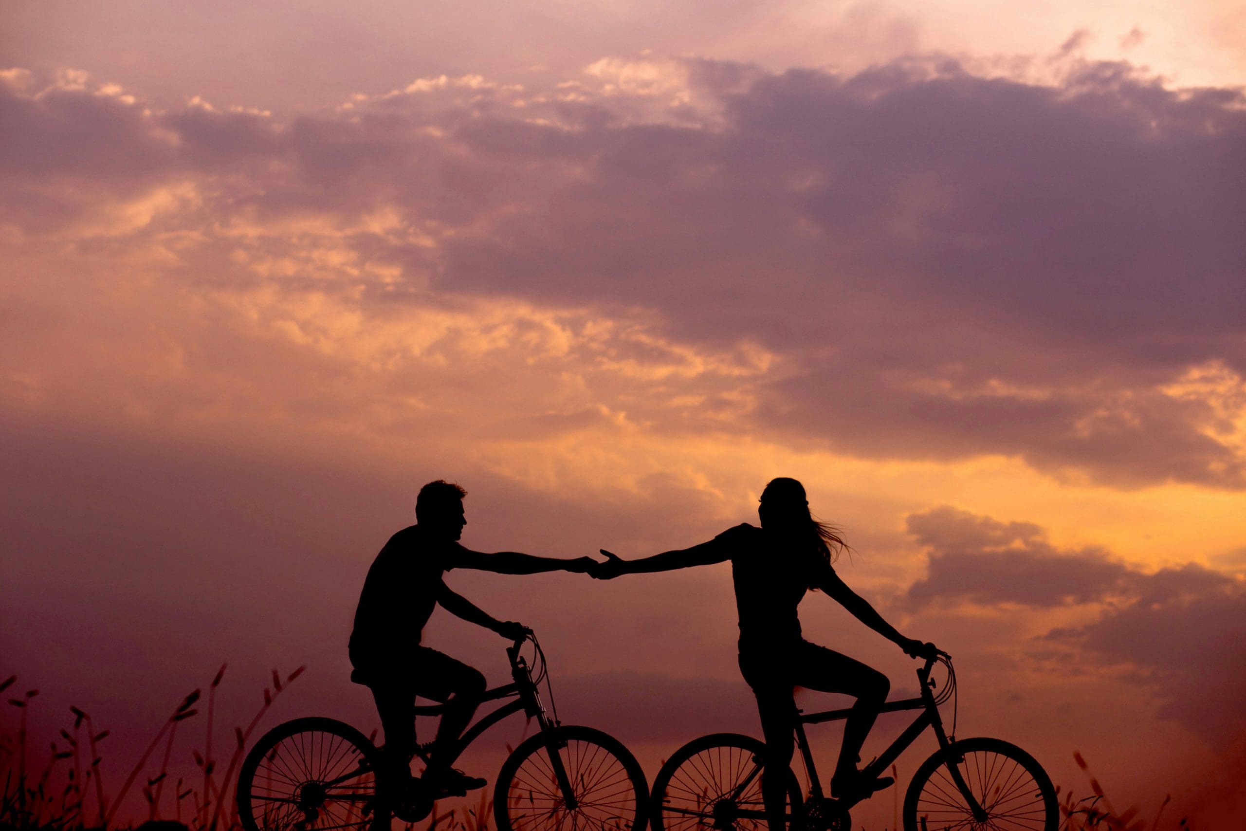 two people riding bikes showing the link between early sobriety and relationships.