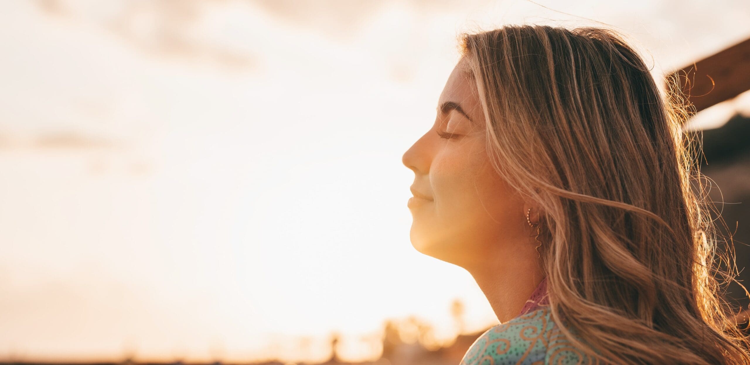 smiling person standing confidently in the sunlight, representing hope and strength